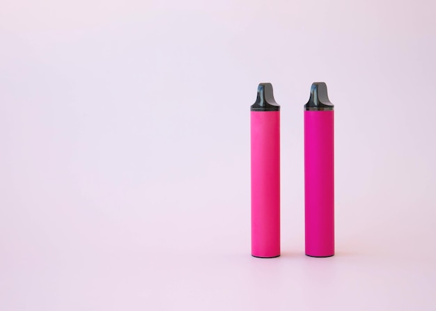 Dois cigarros eletrônicos rosa vape em um fundo rosa