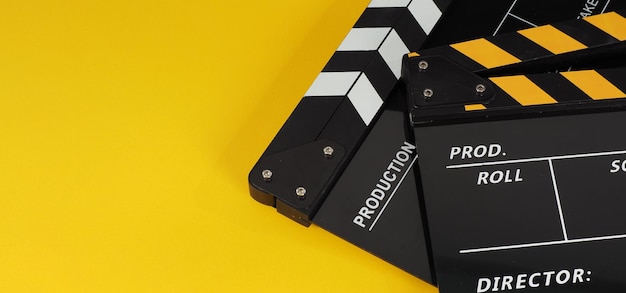 Dois clapper board preto e amarelo ou slate.it filme usam na produção de vídeo, filme, indústria de cinema em fundo amarelo.