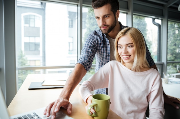 Dois colegas alegres no escritório de coworking