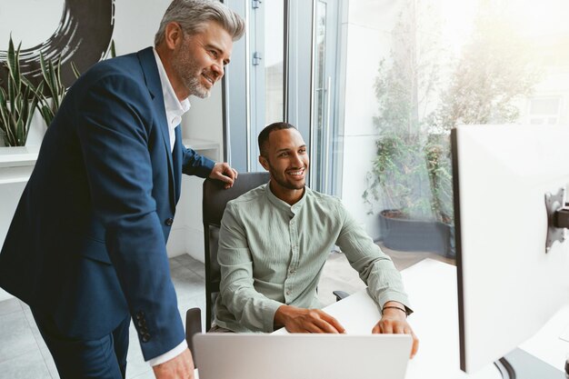 Dois colegas de negócios multiétnicas trabalhando juntos no escritório moderno