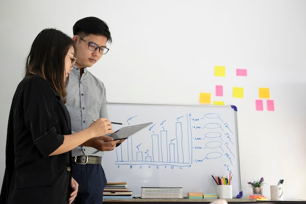 Dois colegas de trabalho discutindo a estratégia do projeto no escritório moderno.