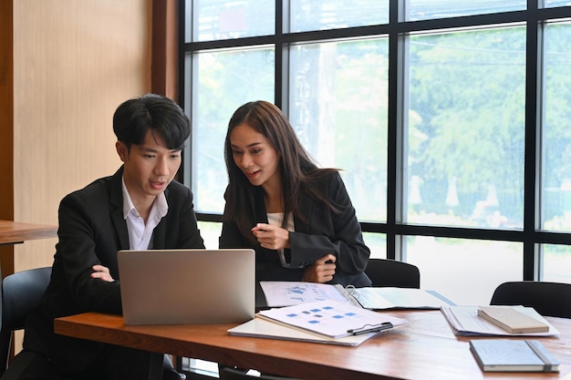 Dois colegas de trabalho discutindo sobre trabalho no interior do escritório moderno