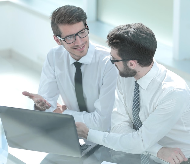 Dois colegas de trabalho olhando para a tela do laptop