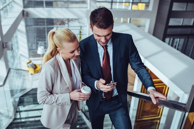 Dois colegas de trabalho usando tecnologia durante o intervalo do escritório