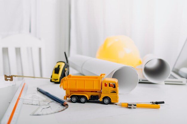 Dois colegas discutindo dados de trabalho e laptop tablet com projeto arquitetônico no canteiro de obras na mesa do escritório