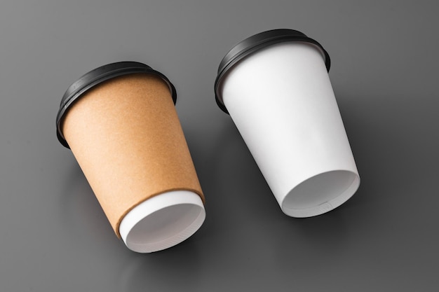Dois copos de café de papel em fundo cinzento