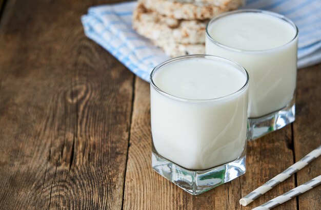 Dois copos de iogurte fresco em uma mesa de madeira