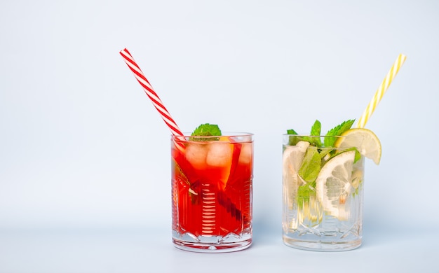 dois copos de limonada com limão, limão e folhas de hortelã, pêssego e gelo