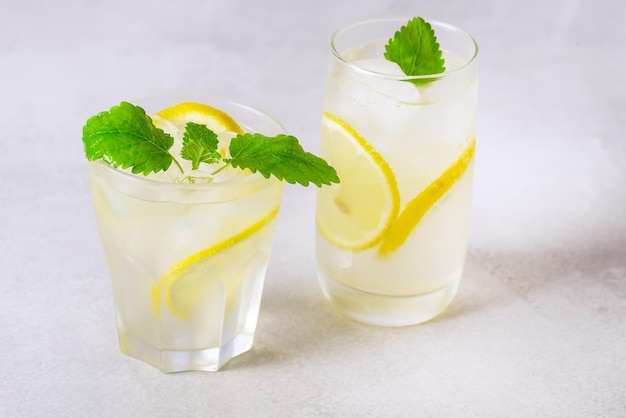 Dois copos de limonada feita na hora com hortelã e cubo de gelo bebida saudável fundo cinza