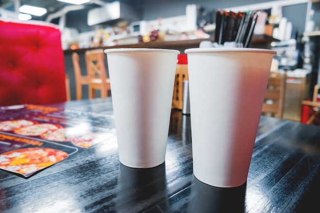 Dois copos de papel branco com café na mesa de café