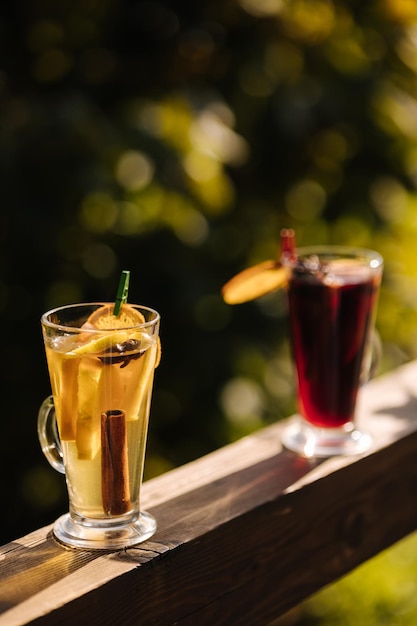 Dois copos de sangria estão em uma grade, um dos quais contém uma bebida vermelha.