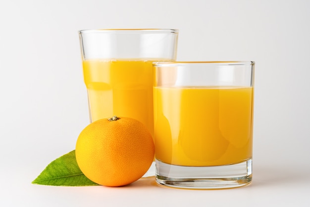 Dois copos de suco de laranja em branco.