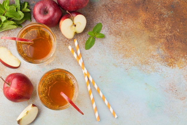 Dois copos de suco de maçã vermelha.