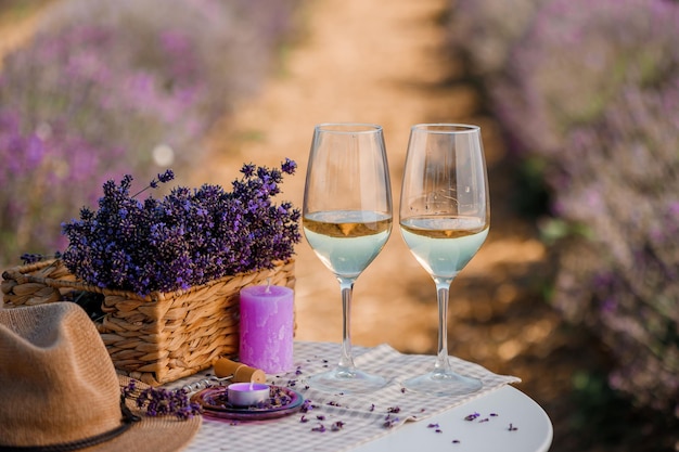 Dois copos de vinho branco em um campo de lavanda em flores Provance Violet no fundo