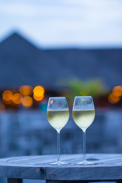 Dois copos de vinho branco saboroso ao pôr do sol