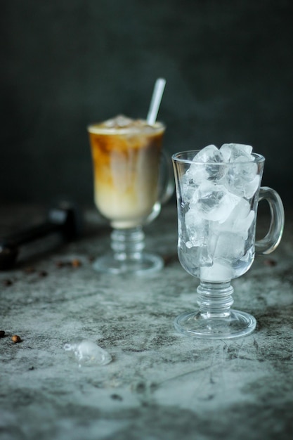 Dois copos transparentes com gelo e com café gelado preto caseiro com creme