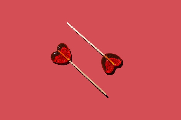 Dois corações de pirulitos em um padrão de fundo vermelho