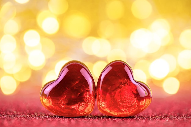 Dois corações de vidro vermelho no contexto das luzes. amor mútuo, declaração de amor