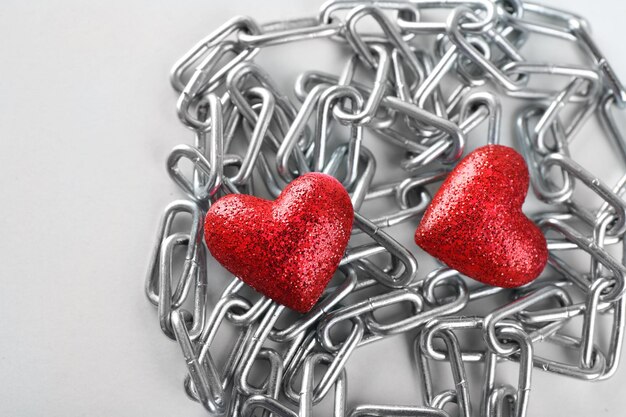 Dois corações vermelhos com corrente de metal, closeup