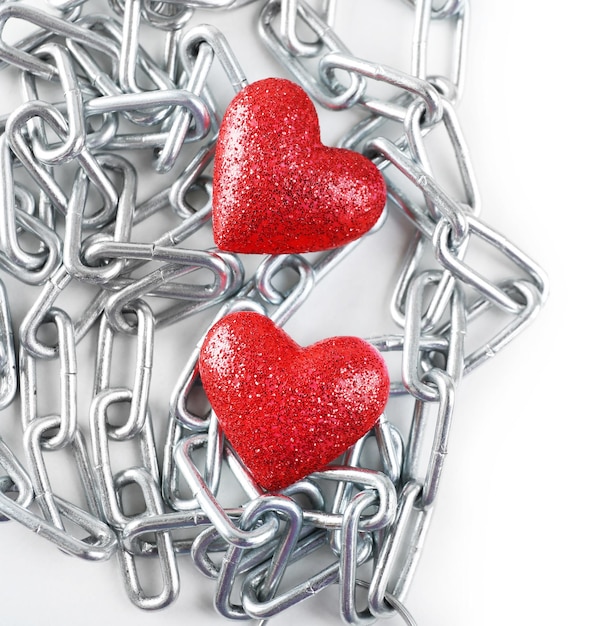 Dois corações vermelhos com corrente de metal isoladas em branco