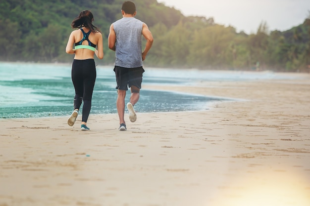 Dois corredores fazendo jogging com atletas na praia