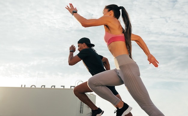 Dois corredores saltando durante uma corrida em um telhado