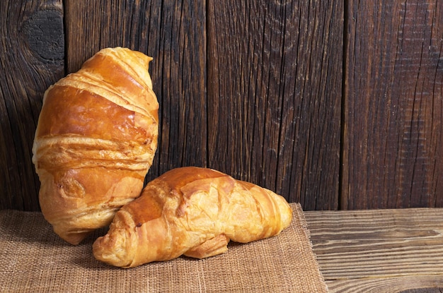 Dois croissants frescos na mesa de madeira rústica