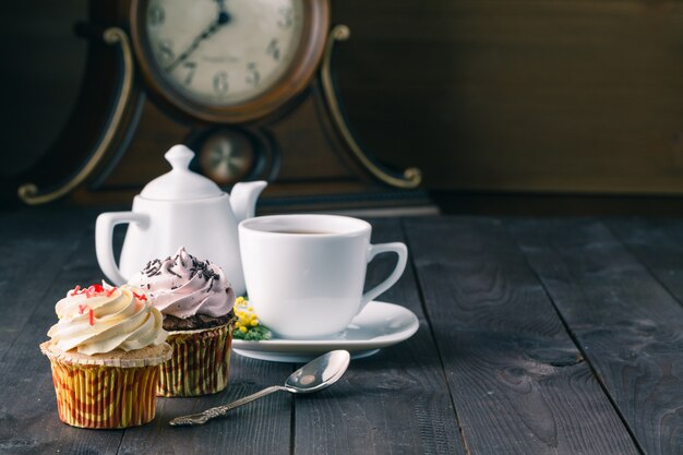 Dois cupcakes na mesa de madeira escura