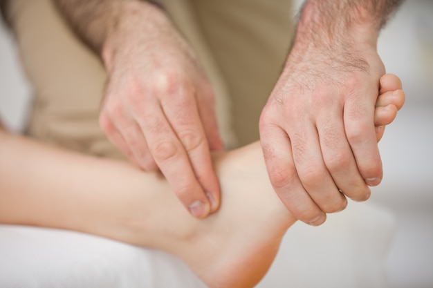 Dois dedos tocando e massageando um pé