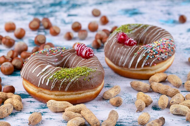 Dois deliciosos donuts de chocolate com nozes saudáveis colocados sobre uma mesa de pedra.