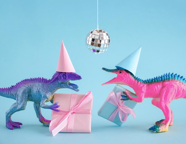 Foto dois dinossauros funky com caixas de presentes e bola de discoteca em fundo rosa ideia de cartão de aniversário feliz