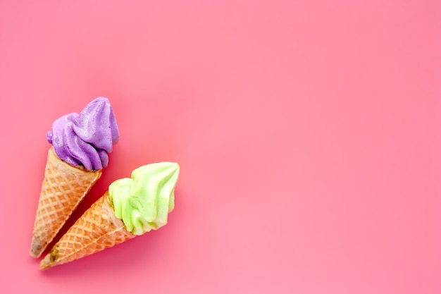 Dois do cone de gelado no fundo cor-de-rosa para o conceito doce e refrescando da sobremesa