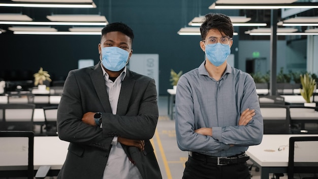 Dois empresários africanos colegas gerentes de parceiros de negócios usando máscaras faciais para proteger