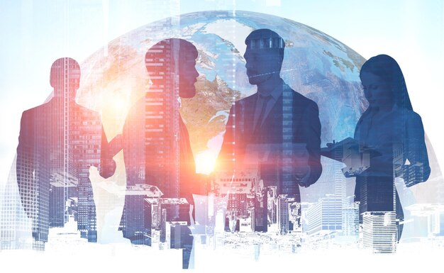 Dois empresários apertando as mãos de seus colegas de pé perto deles com dupla exposição da cidade cinza e do planeta Terra. Imagem tonificada. Elementos desta imagem fornecidos pela NASA