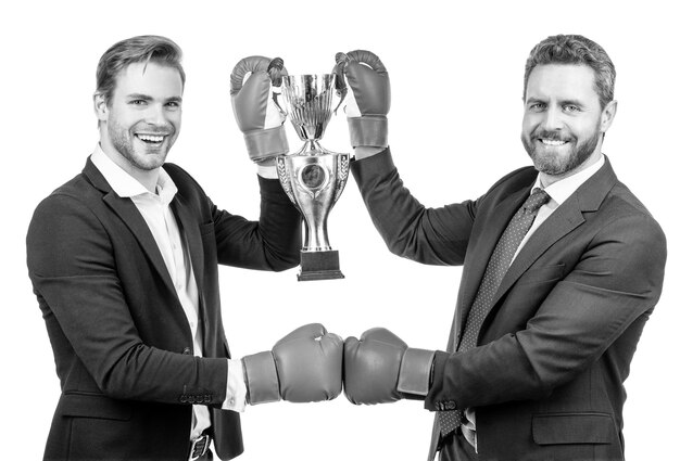 Foto dois empresários felizes em luvas de boxe seguram a taça de campeão dourado após a batalha corporativa pelo campeonato de liderança