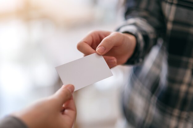 Dois empresários segurando e trocando um cartão vazio