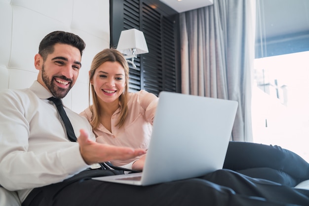 Dois empresários trabalhando juntos no laptop.