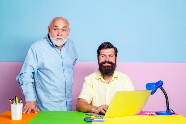 Dois empresários usando o computador juntos discutindo notícias ou filmes, dois colegas trabalhando juntos na ...