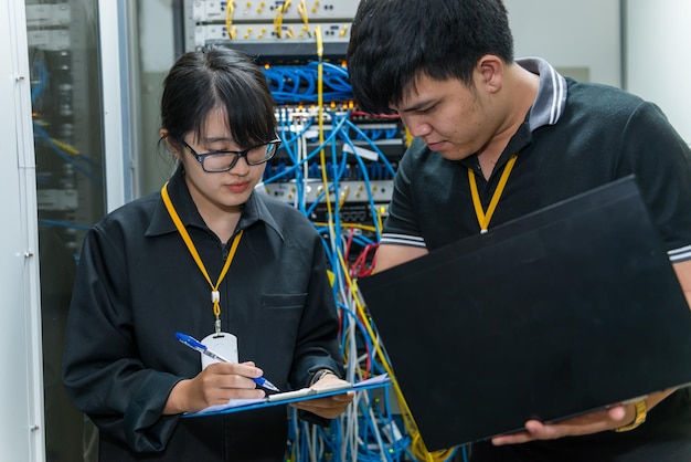 Dois engenheiros asiáticos trabalhando na sala do servidorVerifique os problemas de conexão das redes de computadoresTailândia