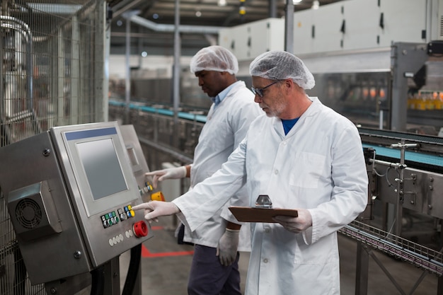 Dois engenheiros de fábrica, operando a máquina na fábrica