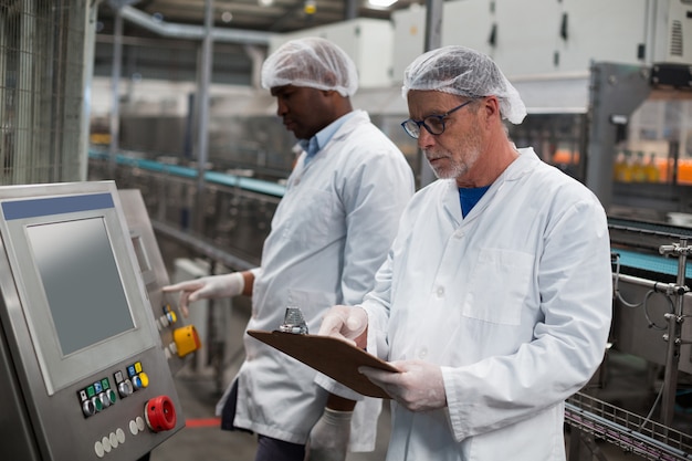 Dois engenheiros de fábrica, operando a máquina na fábrica