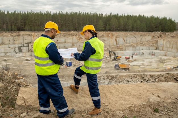 Dois engenheiros discutindo esboço de construção no local de trabalho