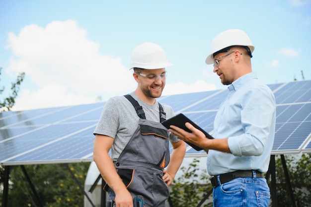 Dois engenheiros estão realizando inspeção externa de painéis solares fotovoltaicos