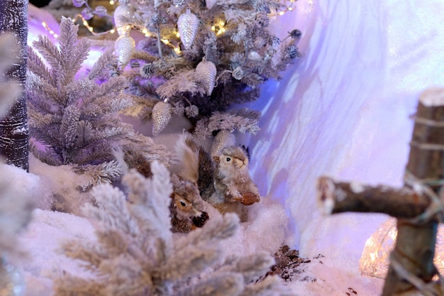 Dois esquilos com cones sob uma árvore de neve Instalação de esquilos de ano novo