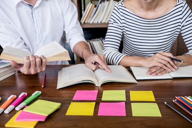 Dois, estudantes, ou, colegas, grupo, sentando, em, biblioteca, com, ajuda, amigo, fazendo, dever casa, e, lição, prática