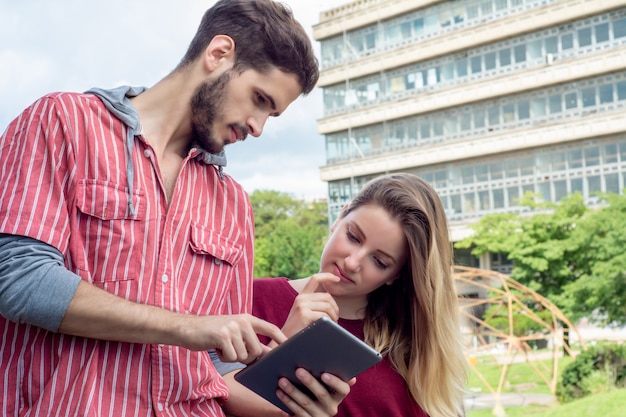 Dois estudantes universitários estudando juntos ao ar livre