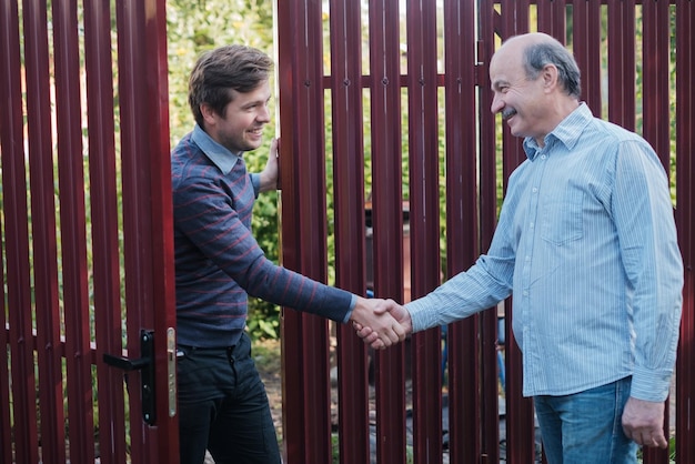 Dois fazendeiros apertando as mãos e conversando um com o outro