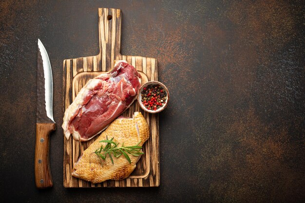 Foto dois filetes de peito de pato crus não cozidos com pele temperada com