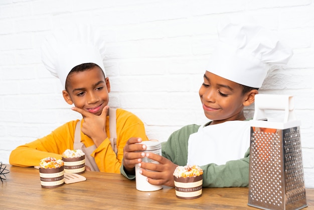 Dois filhos de irmãos afro-americanos vestidos como chef