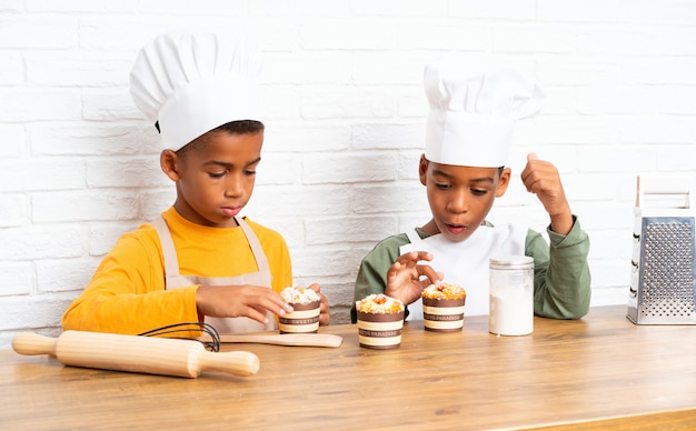 Dois filhos de irmãos afro-americanos vestidos como chef